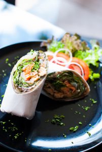 Roasted salmon salad wrap with lemon, capers, mayo, lettuce, tomato, and onion. A great lunch for on-the-go or as a weekday lunch.