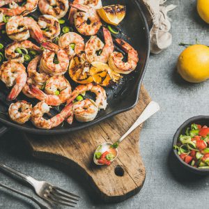 Grilled shrimp, salmon, vegetables, and lemon displayed on a board. Great for entertaining, as an appetizer, or a weekend dinner.